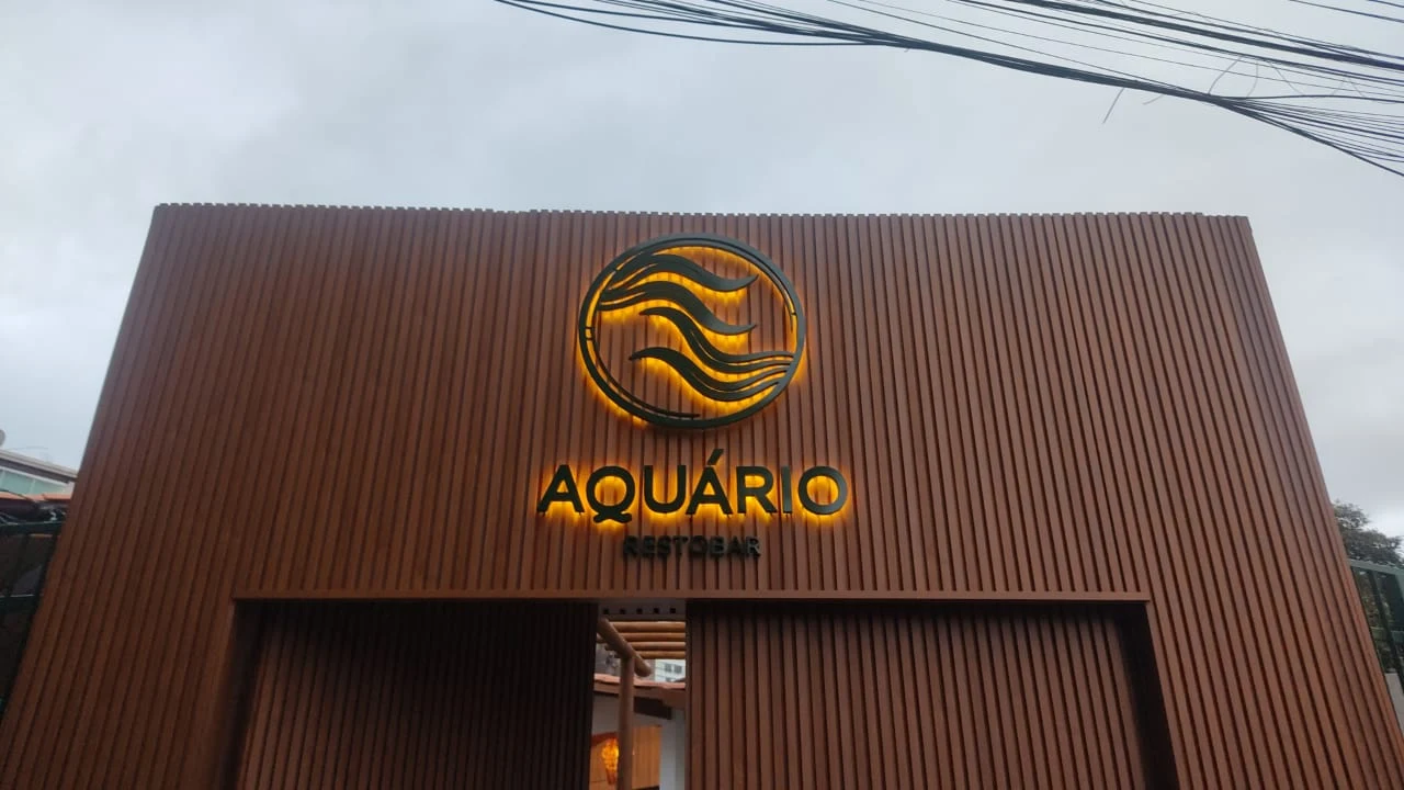 Fachada do Aquário com revestimento amadeirado e letreiro dourado