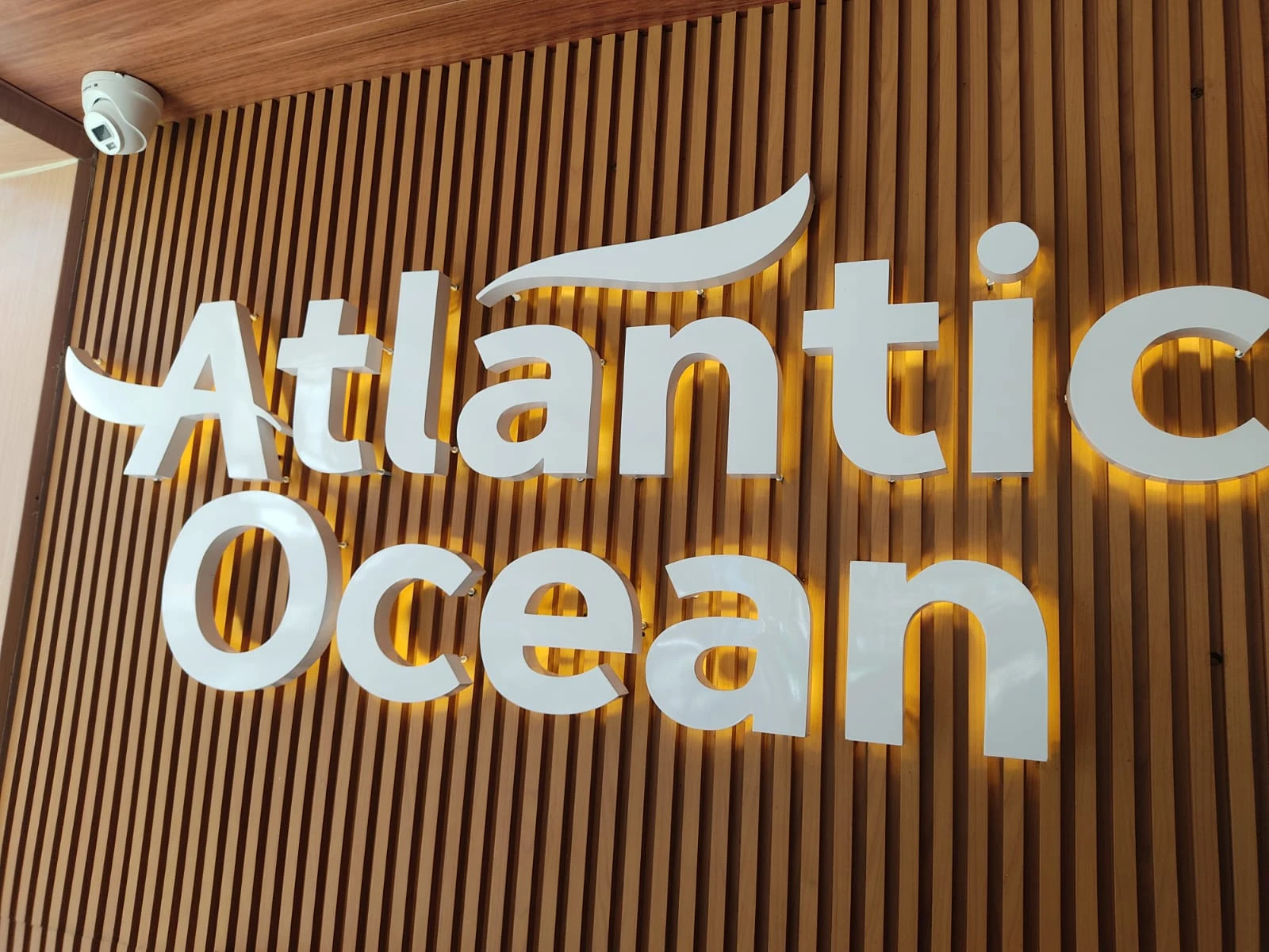 Letreiro Atlantic Ocean sobre painel de madeira